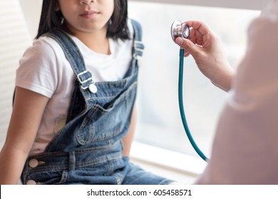 Professional Medical Pediatrician Doctor In White Uniform Listen Lung And Heart Sounds Of  Sick Illness Child Patient With Stethoscope: Physician Check Up Kid Female Patient After Consult In Hospital