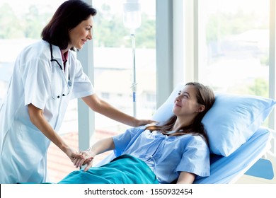 Professional medical service concept. Caucasian doctor smiling take care of a young patient girl in hospital. Friendly nurse or therapeutic treat client to be happy in nursing home. - Shutterstock ID 1550932454