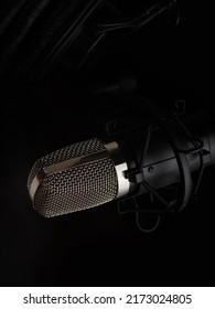 Professional Microphone On A Black Background. Minimalism. Close-up. Recording Studio, Music Studio, Vocal, Concert, Night Club, Karaoke, Rehearsal, Debate, Radio, TV.