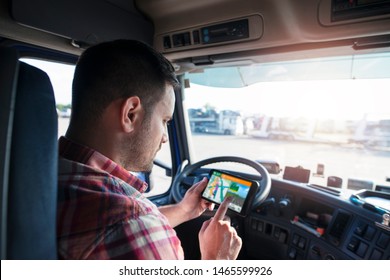 Professional middle aged trucker using truck gps navigation to transport and deliver goods to the destination. Transportation services.