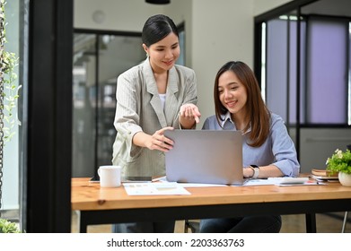 Professional Millennial Asian Female Boss Is Training And Giving Some Advice To Her New Assistant, Working Together As A Team.