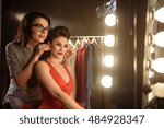 Professional model preparing for podium with assistant help