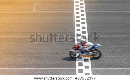 Professional motorbike in leather suit and safety helmet on race track, Man riding motorcycle in asphalt road on motor circuit crossing start and finish line.