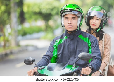 Professional Motorcycle Taxi Driver Taking A Passenger To Her Destination