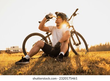 A professional mountain bike cyclist drinking water from the bottle active healthy lifestyle. - Powered by Shutterstock