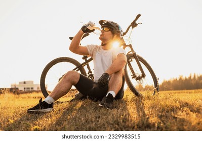 A professional mountain bike cyclist drinking water from the bottle active healthy lifestyle. - Powered by Shutterstock