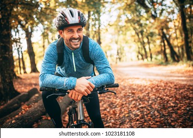 Professional mountain bike cyclist riding trail in forest, details of sports. Toothy smile.