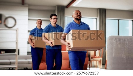 Professional Movers Smiling While Holding Boxes in Residential Room