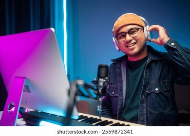 Professional Musician with condenser microphone and tablet for Mixing Mastering music. Music composer male composing a song with guitar and piano keyboard at digital Recording home studio - Powered by Shutterstock