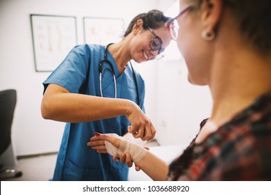 Professional nurse at the hospital bandaging the hand with a medical bandage for a woman patient. - Powered by Shutterstock