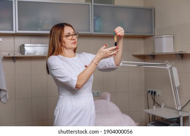 Professional Nurse In A White Coat Holding A Test Tube With Blood Plasma. Collection Of Blood. Medicine Concept