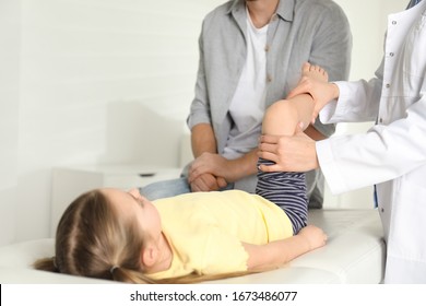 Professional orthopedist examining little patient's leg in clinic - Powered by Shutterstock