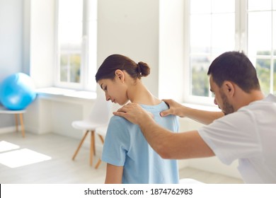 Professional osteopath during work with patient concept. Man chiropractor or osteopath touching and fixing woung womans back and shoulders during visit and treatment in manual therapy clinic interior - Powered by Shutterstock