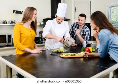 Professional Personal Chef Cook In Customer's Private Kitchen House Giving A Cooking Lesson To Young People At Home