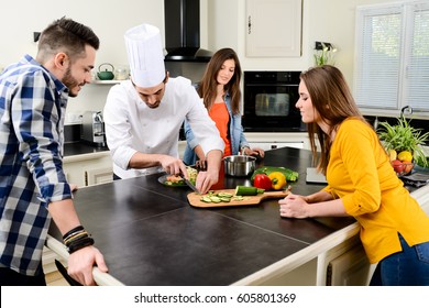 Professional Personal Chef Cook In Customer's Private Kitchen House Giving A Cooking Lesson To Young People At Home