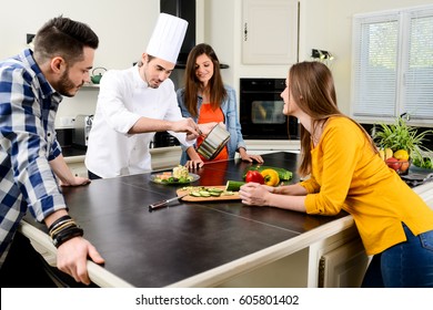 Professional Personal Chef Cook In Customer's Private Kitchen House Giving A Cooking Lesson To Young People At Home