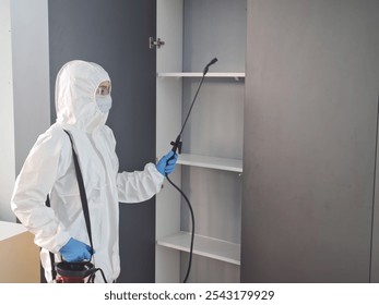 Professional pest control technician disinfects a cabinet in a residential space to ensure safety and cleanliness - Powered by Shutterstock