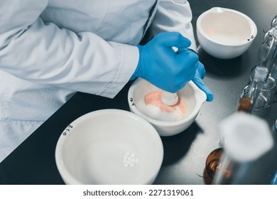 Professional pharmacist grinding a medical preparation using a mortar and pestle, pharmacy and medicine concept. Selective focus and little bit of foreground and depth of field - Powered by Shutterstock