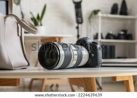 Professional photo camera on table in office, closeup