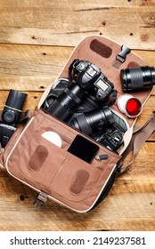 Professional photo equipment in a photo bag on a wooden table, top view. Place for text