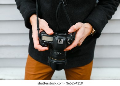 A professional photographer adjusts the camera before shooting, hands, camera, background - Powered by Shutterstock