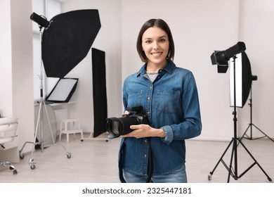 Professional photographer with camera in modern photo studio - Powered by Shutterstock