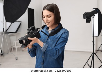 Professional photographer with camera in modern photo studio - Powered by Shutterstock