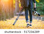 professional photographer with camera and tripod in autumn.