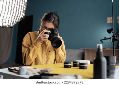 Professional photographer taking photo of cosmetic products on desktop, using camera and natural light Indoors. Blogging, profession and people concept - Powered by Shutterstock