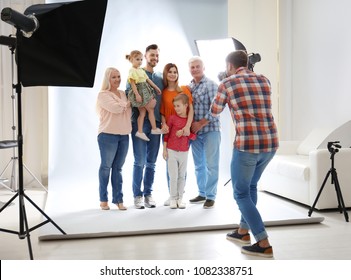 Professional Photographer Taking Photo Of Family In Studio