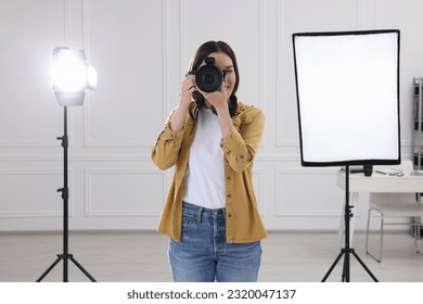 Professional photographer taking picture in modern photo studio - Powered by Shutterstock