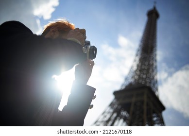 Professional photographer at work in the city centre of Paris near the Eiffel Tower