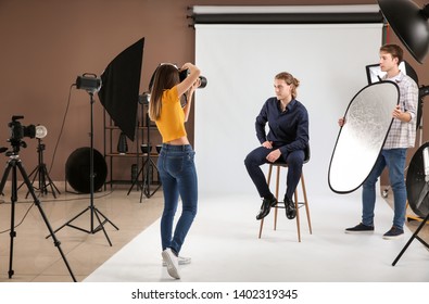 Professional photographer working with model in studio - Powered by Shutterstock