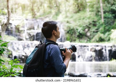 Professional photographers capture the beauty of nature with photographic equipment at a tropical waterfall.Concept of Photography and Travel