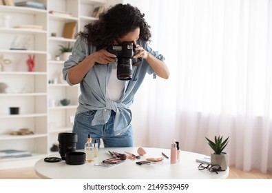 Professional Photography. Blogger Woman With Camera Taking Photos Of Makeup And Skincare Products Standing Near Desk At Home. Beauty Blogging Career Concept