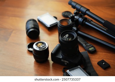 Professional Photography Equipment: Camera, Lenses, Tripod, and Accessories on Wooden Table - Powered by Shutterstock