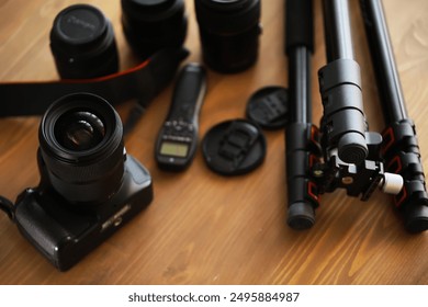 Professional Photography Equipment: DSLR Camera, Lenses, Tripod, and Accessories on Wooden Surface - Powered by Shutterstock