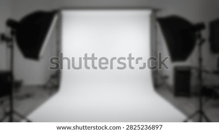 A professional photography studio setup featuring softbox lights on stands and a seamless white backdrop for product or portrait photography.