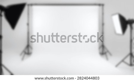 A professional photography studio setup with two softbox lights and a white backdrop, ready for a photoshoot.