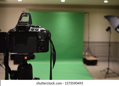 Professional Photography Studio Showing Behind The Scenes Lights, Set Up And Green Screen Blurred In The Background.