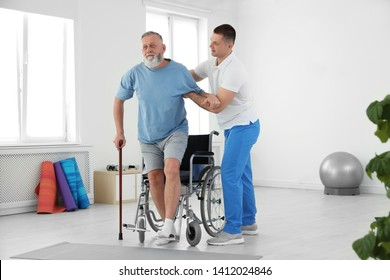 Professional physiotherapist working with senior patient in rehabilitation center - Shutterstock ID 1412024846
