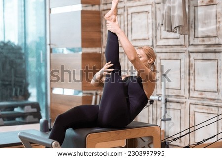 Professional pilates exercise for relaxation blonde woman lying on reformer strengthening and relaxing body young female person in sportswear enjoying training in studio
