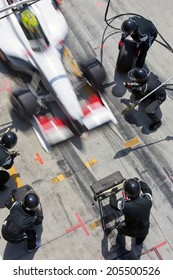 Professional Pit Crew Ready For Action As Their Team's Race Car Arrives In The Pit Lane During A Pitsstop Of A Car Race, Concept Of Ultimate Teamwork