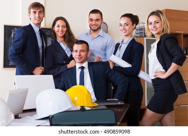 Professional planners with helmets posing in a architecture bureau 