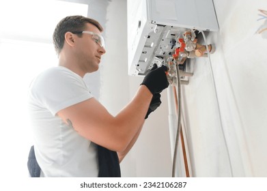 Professional plumber checking a boiler and pipes, boiler service concept.