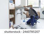 Professional plumber checking drain pipes at home and using pliers