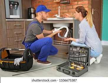 Professional Plumber With Client Near Kitchen Sink