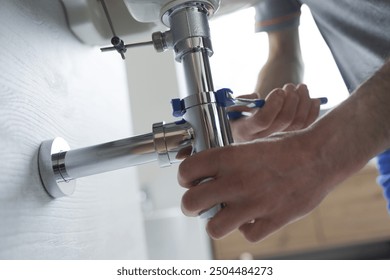 Professional plumber fixing a faulty bathroom sink, he is using water pump pliers