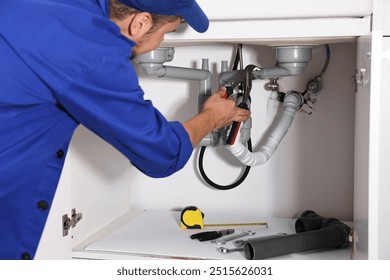 Professional plumber fixing piping system at home