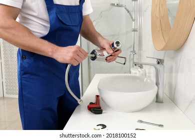 Professional Plumber Fixing Water Tap In Bathroom, Closeup